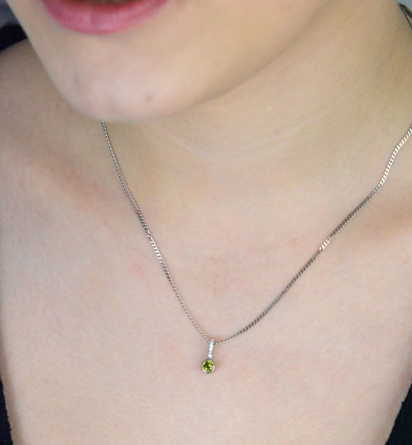 Subtelna srebrna zawieszka z zieloną cyrkonią i białymi zdobieniami u góry. Próba 925, model W 2106, waga 0,70 g, wymiary 1,2 x 0,4 cm. Lekka i elegancka ozdoba..jpg